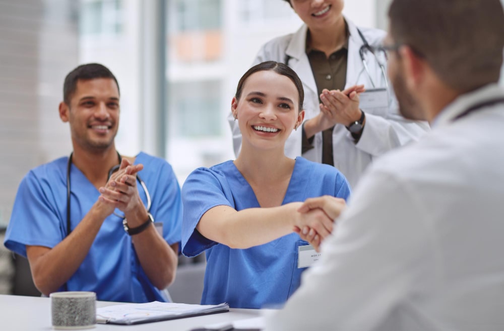 their-board-meeting-was-quite-successful-today-shot-group-medical-practitioners-shaking-hands-applauding-during-meeting-hospital-boardroom (1)-min